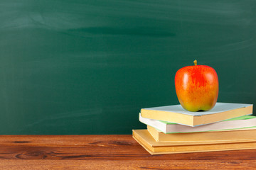back to school - apple and books with pencils and blackboard