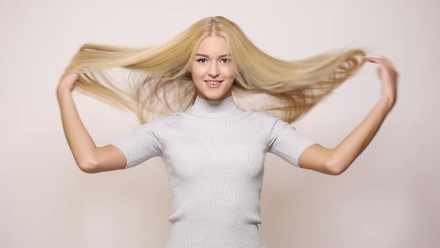Woman  playing with blond long hair on white background