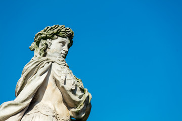 Fototapeta na wymiar Classic statue in a park with blue sky on background