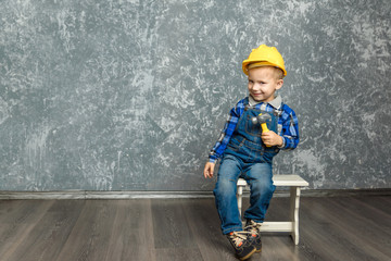 the boy in yellow hard hat holding a hammer