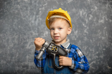 Boy in hard hat with drill, screwdriver in hand