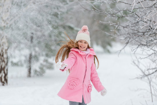 Little girl throws snow up in the air