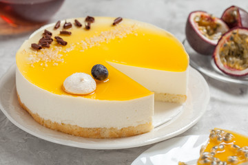 cheesecake with the passion fruit coulis on the black and wooden background