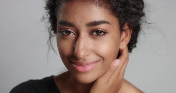 Portrait closeup video of a gorgeous natural looking relaxed and happy Middle Eastern girl with beautiful olive skin