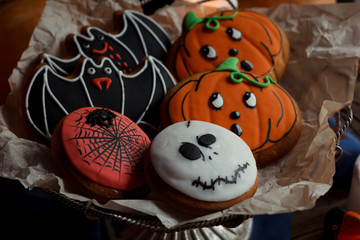 Halloween cookies, pumpkins and candles on table. Vintage decorations, wooden rustic old table. Halloween holiday concept