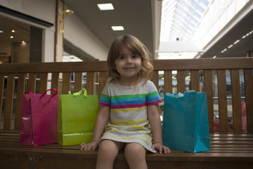 Happy girl holding shopping bags at the mall