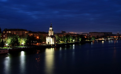 Fototapeta na wymiar Beautiful church with illuminating at night, lights reflected in the water. View of the Dnipropetrovsk Embankment (Dnepr, Dnepropetrovsk, Dnipro). Ukraine