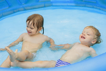 Fototapeta na wymiar Children swim in the inflatable pool