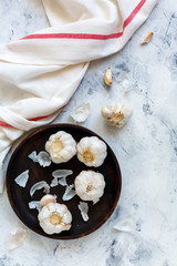 Garlic, clove and peel on a wooden platter.