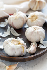 Garlic, cloves and peel on a wooden dish.