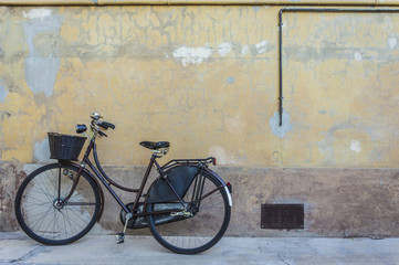 Fototapeta na wymiar Retro bicycle with basket in front of the old wall, background
