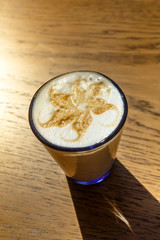 Cappuccino coffee is poured into a glass. Sunny morning, Breakfast