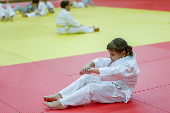 Little judo girl practising back fall - Powered by Adobe