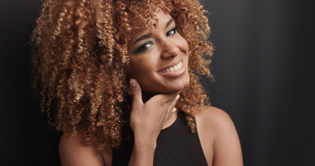 Fototapeta premium Pretty black girl with big hair posing video on black background