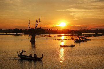 Sunset landscape with boats near famous U Bein bridge near Mandalay in Myanmar