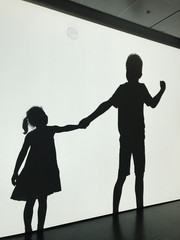 Silhouettes of a boy and a girl holding hands