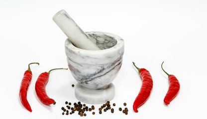 Chili pepper, stone mortar and pestle isolated on white background