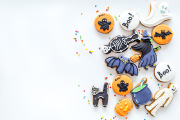 Bright halloween gingerbread cookies background with bat, witch, skeleton, ghost on white background top view copyspace