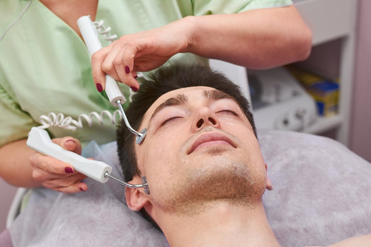 Face of man, microcurrent therapy. Cosmetology procedure in the clinic.