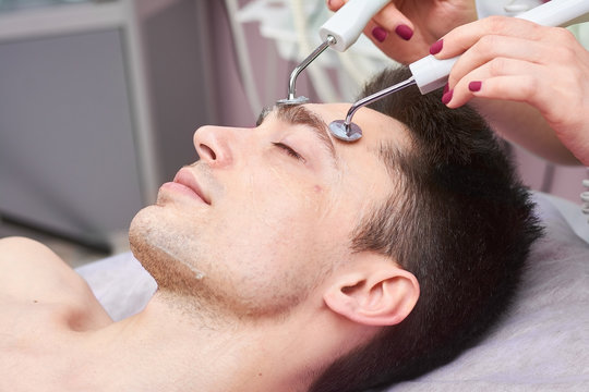 Close up of microcurrent therapy. Face of handsome man, cosmetology.