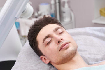 Fototapeta na wymiar Man in the hospital. Young male with eyes closed. Facts about general anesthesia.