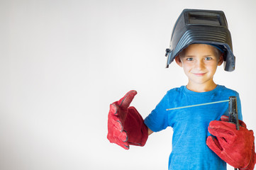 Happy little kid in welder mask and welding equipment. Welding equipment, welding mask, protective...