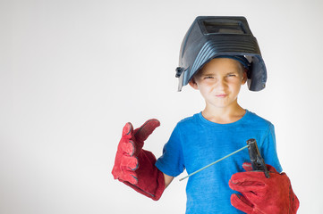 Happy little kid in welder mask and welding equipment. Welding equipment, welding mask, protective...