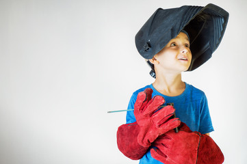 Happy little kid in welder mask and welding equipment. Welding equipment, welding mask, protective...