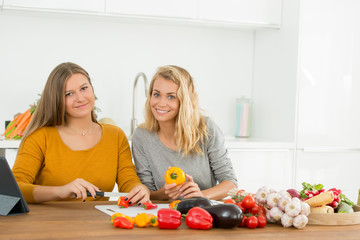 young woman teaching teenager how to cook healthy food