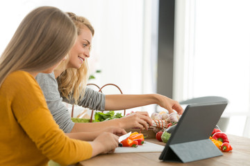 young woman teaching teenager how to cook healthy food