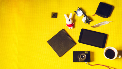 vacation and travel. soft toy, coffee, camera, pen, black notepad for notes. view from above