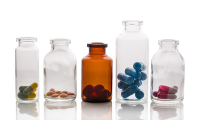 colored pills in a transparent bottle on a white background