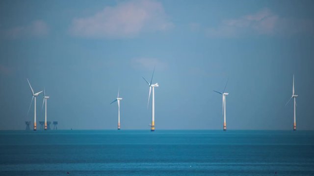 timelapse of offshore wind turbines producing clean renewable energy in the north sea, kent, uk