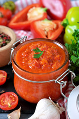 Adjika is a Georgian national sauce made of pepper, garlic and spices on a black background. Sauce. Food background.