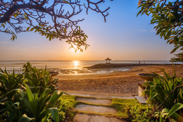 Naklejka premium Beautiful sunrise on a beach in Bali Indonesia with colourful sky as background