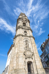 Fototapeta na wymiar Prospective view of the iconic baroque Clerigos Tower, one of the landmarks and symbols of the city of Porto in Portugal. Sunny day in the blue sky.