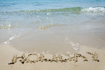 holiday written on the beach