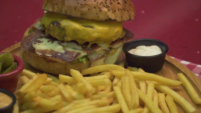 Burger with fries, onion rings, pickles and sauces. Hamburger menu.