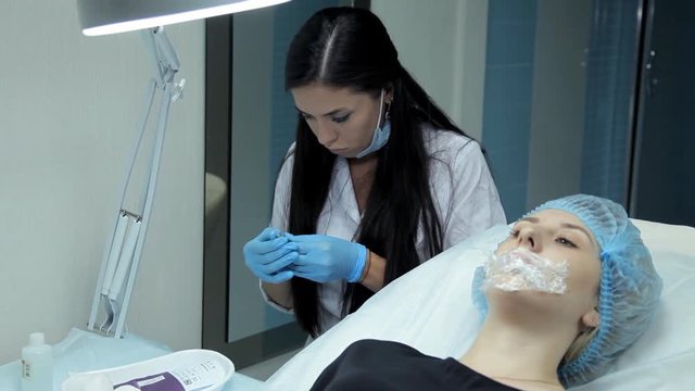 The doctor-cosmetologist will print a syringe with hyaluronic acid before starting the procedure to increase the lips.