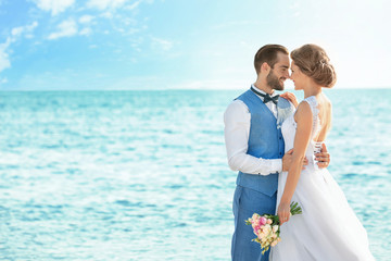 Happy wedding couple on sea beach