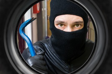 Thief or burglar behind door. View from peephole.