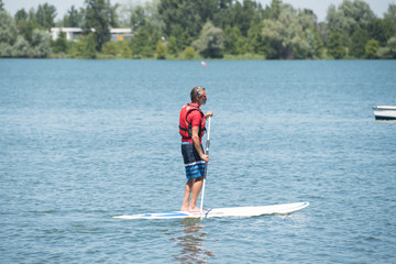 man enjoying a ride on the lake with paddleboard