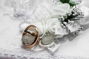 gold wedding rings on a white pillow