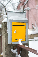 Snow covered mailbox in front of a house