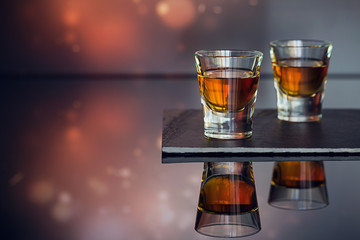 Cognac or liqueur, coffee beans and spices on a glass table.