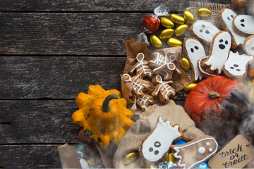 Funny delicious ginger biscuits  shape ghost and skeleton  with pumpkins and sweets. Happy Halloween holiday text 