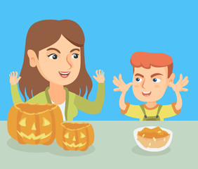 Young caucasian mother and her son carving pumpkins and preparing for Halloween