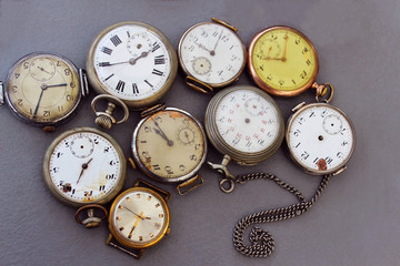Old antique pocket watch on a gray background. Old watches are sold on the flea market.
