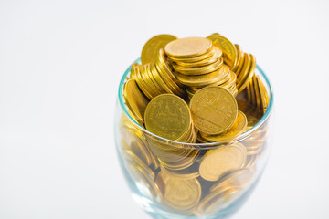 Golden coins in a glass of champagne, on the white background.
