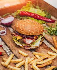 Bacon burger with beef and french fries on wooden table
